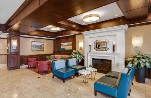 a lobby with blue chairs and a fireplace at Ayres Hotel & Spa Moreno Valley/Riverside in Moreno Valley