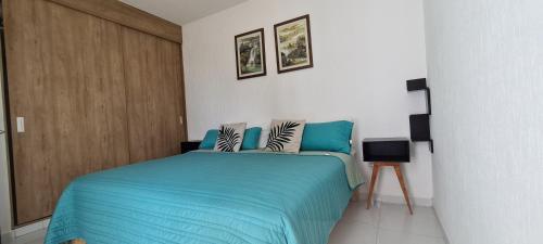 a bedroom with a blue bed and a wooden door at Departamento en condominio con alberca y área infantil in Manzanillo
