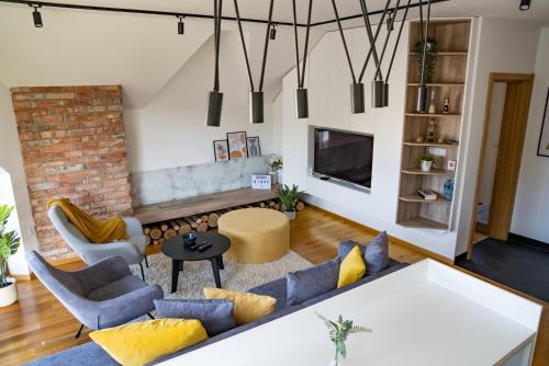 a living room with a couch and chairs and a tv at Sunny Sight Zlatibor in Zlatibor