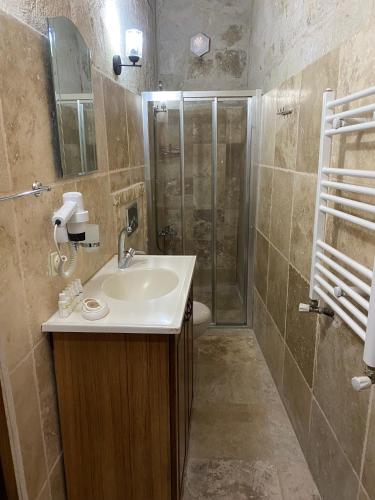 a bathroom with a sink and a shower at Turquaz Cave Hotel in Göreme