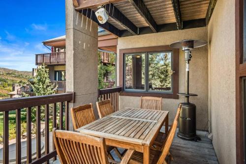 a porch with a wooden table and chairs on a balcony at Ridge 27 in Snowmass Village