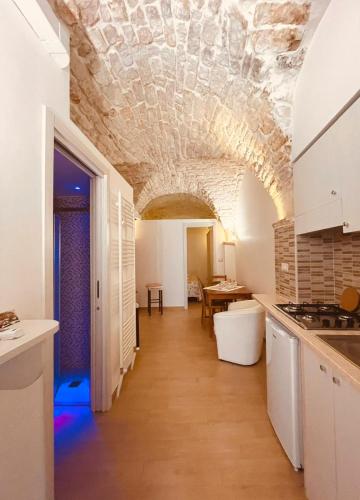 a kitchen with a stone ceiling and a table at Zia Paoletta in Martina Franca