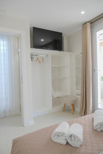 a white bedroom with two towels on a bed at B&B Toci in Volla