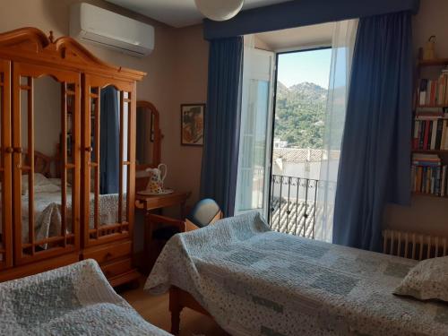 a bedroom with a bed and a large window at Alojamiento Cazorla Visión in Cazorla