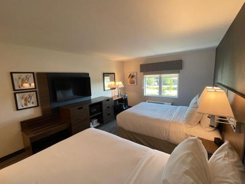 a hotel room with two beds and a flat screen tv at Comfort Inn & Suites in Carleton Place