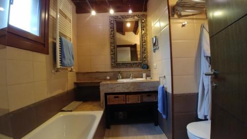a bathroom with a tub and a sink and a mirror at La Calma de Llanes in Llanes