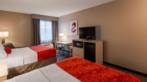 a hotel room with two beds and a flat screen tv at Best Western Plus New Cumberland in New Cumberland