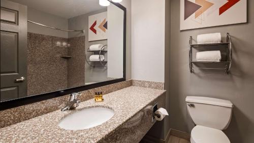 a bathroom with a sink and a toilet and a mirror at Best Western Plus New Cumberland in New Cumberland