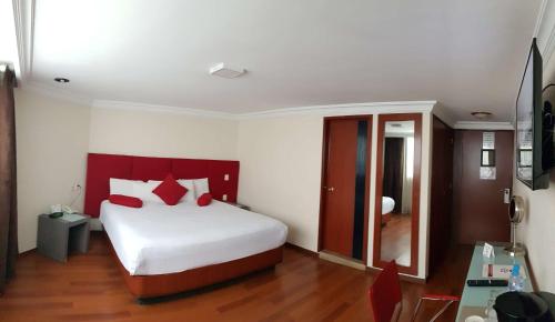 a bedroom with a large white bed with red pillows at Best Western Plus Gran Marques in Toluca