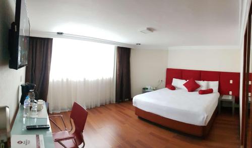 a hotel room with a bed with a red headboard at Best Western Plus Gran Marques in Toluca
