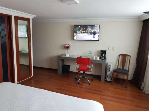 a bedroom with a desk and a red chair at Best Western Plus Gran Marques in Toluca