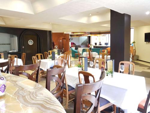 a dining room with white tables and wooden chairs at Best Western Plus Gran Marques in Toluca