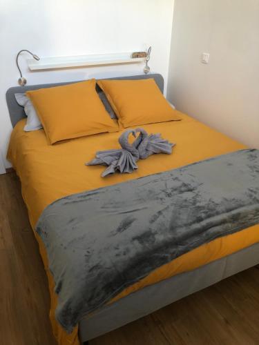 Una cama con sábanas amarillas y una manta azul. en Le Cocon Nocturne 10min Arkema Total en Macheren