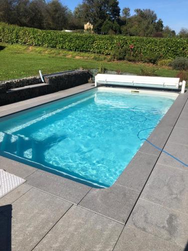 a swimming pool with blue water in a yard at Le Cocon Nocturne 10min Arkema Total in Macheren