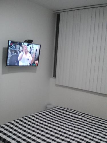 a bedroom with a tv on the wall and a bed at Habitación Privada in Ibagué