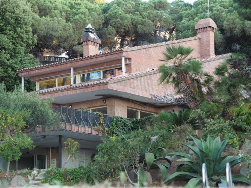 a large brick house on a hill with trees at Villa Maresme & Villa Rosa in Mataró