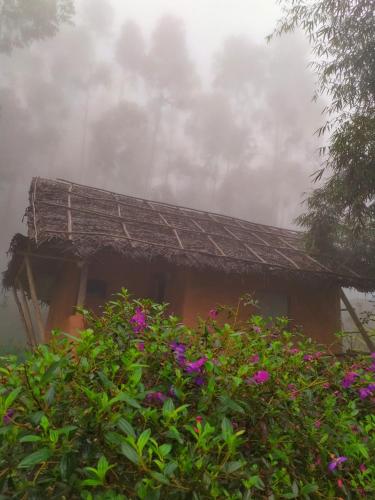 a house with purple flowers in front of it at Anandavana Jungle Living By LexStays - Kanthalloor-Marayur in Kanthalloor