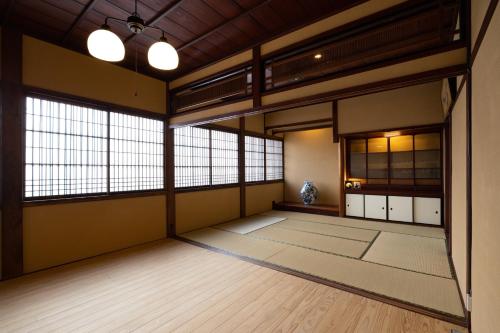 a japanese room with large windows and wooden floors at 龍助２５ in Komatsu