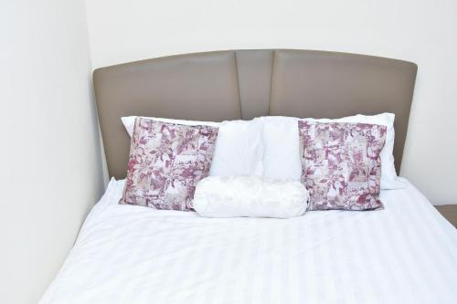 a bed with three pillows on top of it at Amber Apartments G1 Kitengela in Athi River