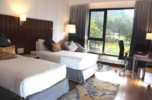 a hotel room with two beds and a window at Vivanta Katra Vaishno Devi in Katra