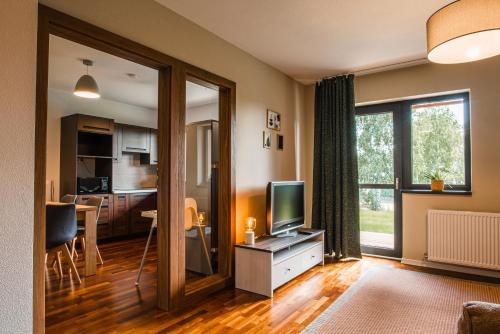 a living room with a television and a kitchen at Bazalt Apartments in Miercurea-Ciuc