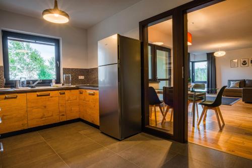 a kitchen with a stainless steel refrigerator and a dining room at Bazalt Apartments in Miercurea-Ciuc