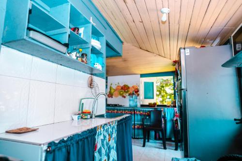 a kitchen with blue cabinets and a refrigerator at Coconut Paradise Lodge in San Andrés