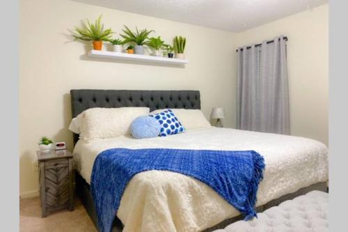1 dormitorio con 1 cama con manta azul y blanca en Bailee's House in Monroe, en Monroe