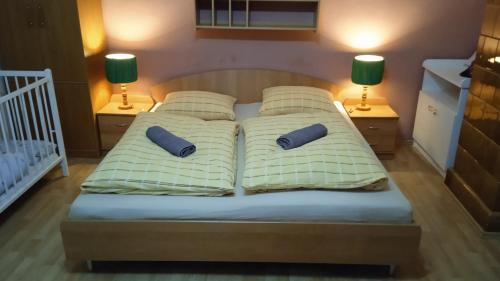 een bed met 2 kussens en 2 lampen bij Apartmán Kristínka in Lendak