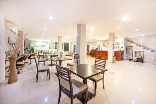 uma sala de jantar com mesas e cadeiras e uma escadaria em Caribe Princess em Chetumal