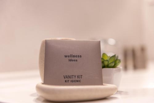 a candle on a table with a sign on it at UpperHouse Suites & More in Braşov