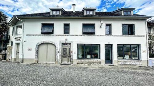 a white house with a door on a street at Chambres d'hôtes Chez Valérie Garage motos et vélos in Arette