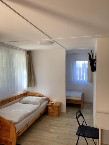 een slaapkamer met een bed en een stoel erin bij Mineral apartman Crystal in Sóstófürdő