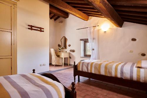 a bedroom with two beds and a mirror at La Rosa in Città di Castello