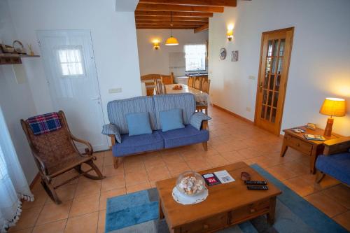 a living room with a blue couch and a table at Casa da Baía in Prainha de Baixo