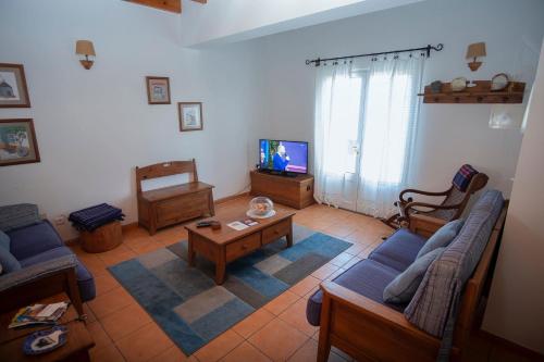 a living room with blue couches and a tv at Casa da Baía in Prainha de Baixo