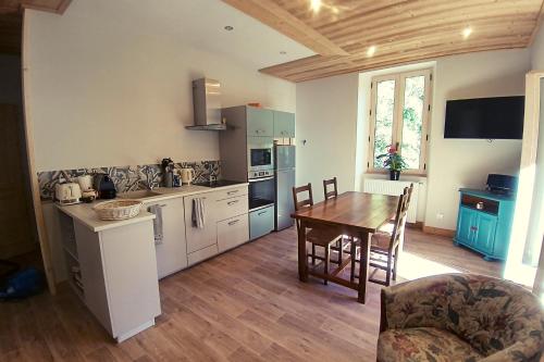 une cuisine avec une table et une salle à manger dans l'établissement Le Balcon du grand bec, à Planay