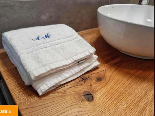 a stack of towels sitting on a table next to a bowl at Alloggi Al Melograno in Marcon