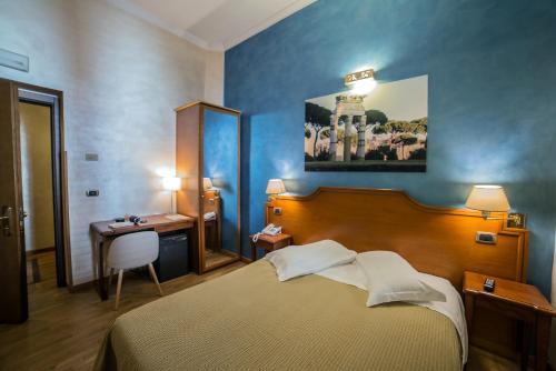 a bedroom with a bed and a table and a desk at Hotel Kent in Rome