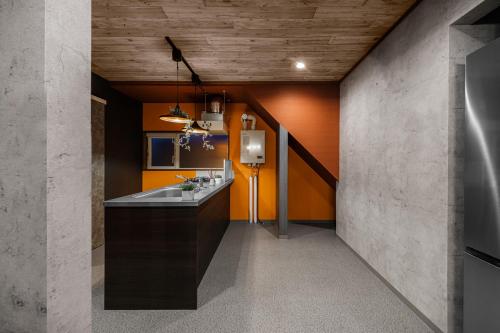 a bathroom with an orange wall and a sink at The Landscape in Kami-furano