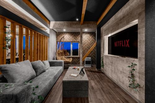 a living room with a couch and a tv at The Landscape in Kami-furano