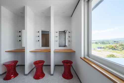 a bathroom with red stools in front of a window at The Landscape in Kami-furano