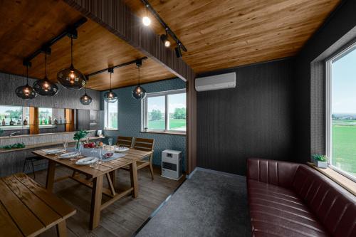 a dining room with a table and a couch at The Landscape in Kami-furano