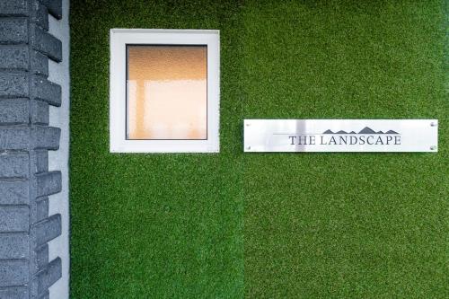 a window in the grass with a sign that reads the landscape at The Landscape in Kami-furano