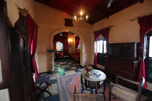 a living room with a table and chairs in a room at Emerson on Hurumzi in Zanzibar City