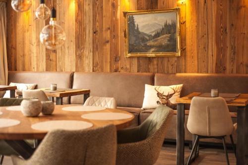 a restaurant with tables and a couch and chairs at Harz hotel Iris in Sieber
