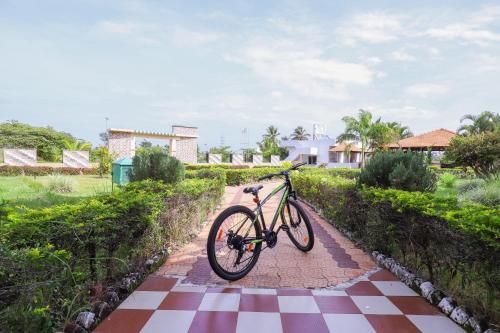 a bike is parked on a checkered sidewalk at Brindavan Garden Resort & Spa in Mysore