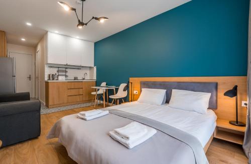 une chambre avec un grand lit avec un mur bleu dans l'établissement B&H2, à Goudaouri