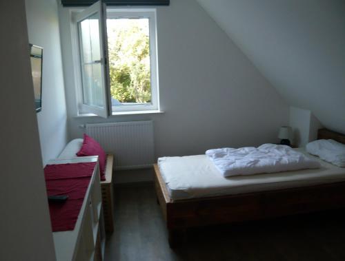 a small bedroom with two beds and a window at Aloha 1 in Neue Tiefe Fehmarn