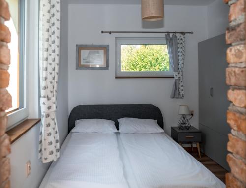 a bed in a bedroom with a window at Dom Morski in Lubiatowo